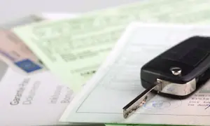 Autoschlüssel liegt auf Dokumenten, darunter ein Schein mit der EVB-Nummer.