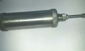 Metallische Handfettpresse mit gerändeltem Griff und Auslauf, ein Beispiel für verschiedene Schmiernippel Arten.