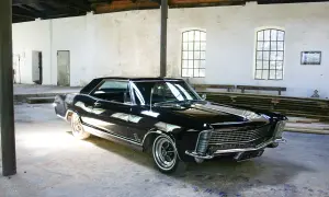 Glänzendes schwarzes Buick Auto steht in einer alten Halle.