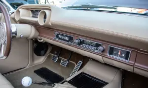 Armaturenbrett eines Oldtimers mit altem Autoradio. Mit einem Adapter lässt sich das alte Autoradio mit dem Handy verbinden, um Musik zu hören.