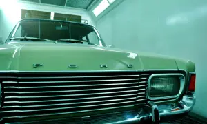 Ein hellgrüner Oldtimer mit Chromgrill und "FORD"-Schriftzug wartet auf das Lackieren. Die Kosten für das Oldtimer lackieren sind hier ein Thema.