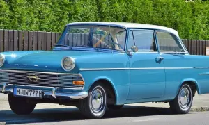 Blauer Oldtimer mit weißem Dach und dem Kennzeichen M UW 777 H. Ein Klassiker auf der Straße.