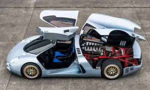 Der Isdera Commendatore 112i mit geöffneten Flügeltüren und Motorhaube zeigt seinen V12-Motor und die rote Gitterrohrrahmen-Konstruktion.