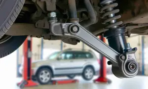 Fahrwerk eines Autos mit Stoßdämpfer und Querlenker. Möglicherweise ein Grund, warum das Auto nach rechts zieht trotz Spureinstellung.