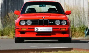 Roter BMW E30 M3 Evolution, ein Klassiker aus den 80ern, steht im Freien.