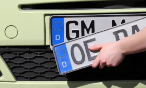 Hand wechselt Kennzeichen. Vorbereitung zum auto ummelden.