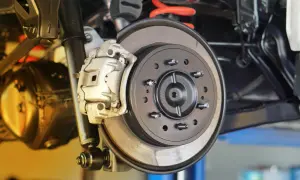 Nahaufnahme einer Autobremsanlage. Ein Mechaniker prüft, wann bremsscheiben wechseln, um die Sicherheit zu gewährleisten.