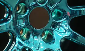 Glänzende Felgen, frisch lackiert in einem auffälligen Türkis. Die Spiegelung des Lichts auf der glatten Oberfläche lässt die Felgen fast lebendig wirken.