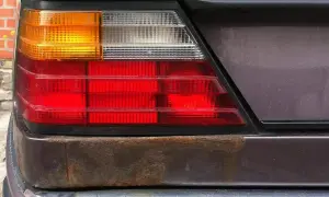 Rost unter Lack am Heckleuchtenbereich eines Autos. Zeit, den Rost unter Lack zu entfernen und das Fahrzeug zu retten.