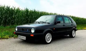 Schwarzer Golf 2 Limited mit blauen Akzenten steht am Feldrand.