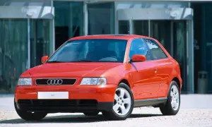 Roter Audi A3 vor einem modernen Gebäude. Ein Klassiker, der bald das Youngtimer Kennzeichen tragen darf.