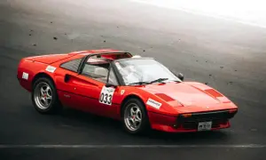 Roter Ferrari 308 GTB mit Startnummer 033 auf der Rennstrecke, bereit für die nächste Runde.