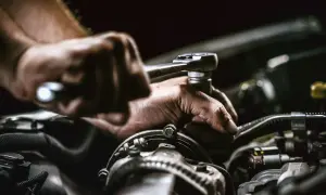 Mechaniker repariert Auto. Die anlasser wechseln kosten sind hier im Fokus.