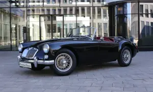 Schwarzer Roadster mit roten Ledersitzen, ein Klassiker unter den englischen Roadster Marken, steht vor einem modernen Gebäude.