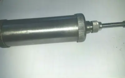 Metallische Handfettpresse mit gerändeltem Griff und Auslauf, ein Beispiel für verschiedene Schmiernippel Arten.