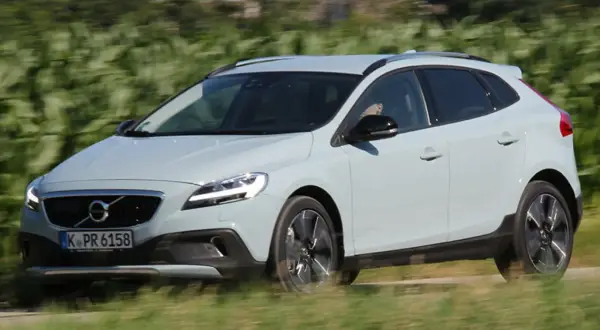 Ein hellblauer Volvo V40 Cross Country fährt auf einer Landstraße.