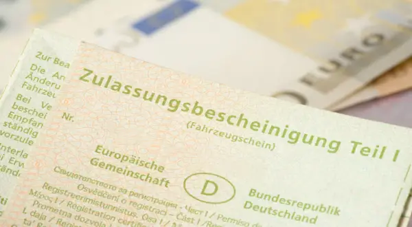 Zulassungsbescheinigung Teil I. Wichtig für auto abmelden nach verkauf ohne brief. Euroscheine im Hintergrund.