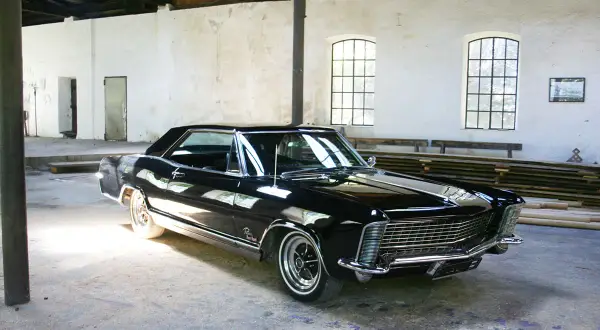 Glänzendes schwarzes Buick Auto steht in einer alten Halle.