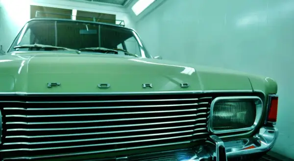 Ein hellgrüner Oldtimer mit Chromgrill und "FORD"-Schriftzug wartet auf das Lackieren. Die Kosten für das Oldtimer lackieren sind hier ein Thema.