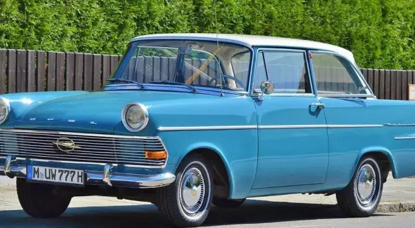 Blauer Oldtimer mit weißem Dach und dem Kennzeichen M UW 777 H. Ein Klassiker auf der Straße.