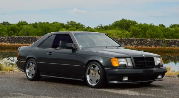 Dunkelgrauer Mercedes Hammer Coupe mit sportlichen Felgen steht am Wasser.