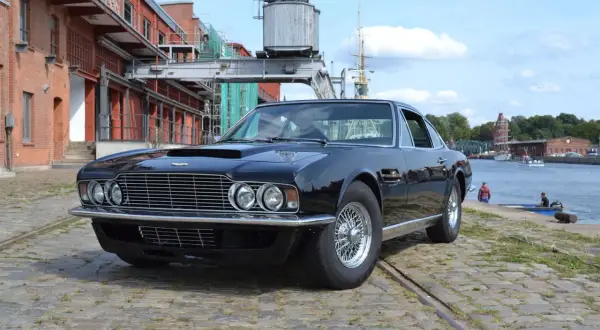 Schwarzer Aston Martin DBS, ein Klassiker unter den englischen automarken 1960, steht am Hafen.