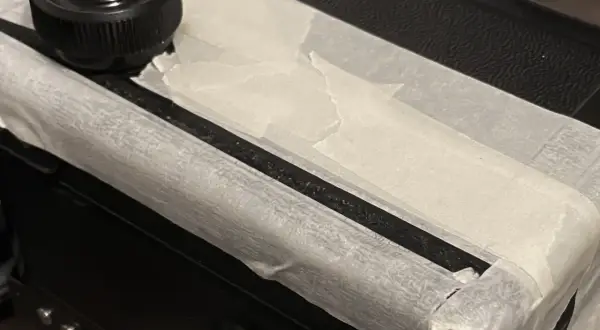 Reparatur einer alten Kamera: Mit Klebeband wird der Riss im Bakelit fixiert, bevor der Kleber trocknet.