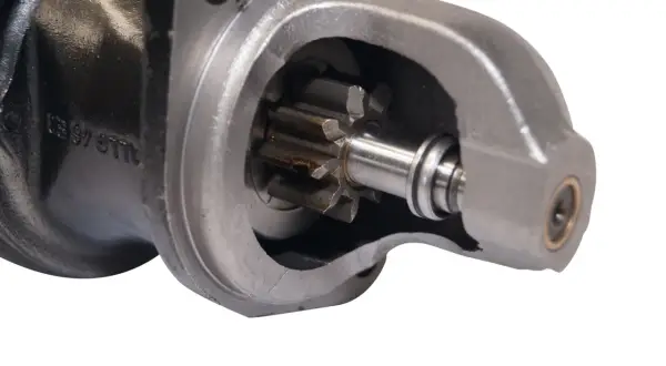 Detailaufnahme eines Anlassers, der zeigt, wie das Ritzel in das Gehäuse greift. Ein Anlasser ist entscheidend, um den Motor zu starten.