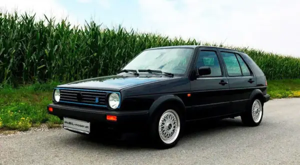 Schwarzer Golf 2 Limited mit blauen Akzenten steht am Feldrand.