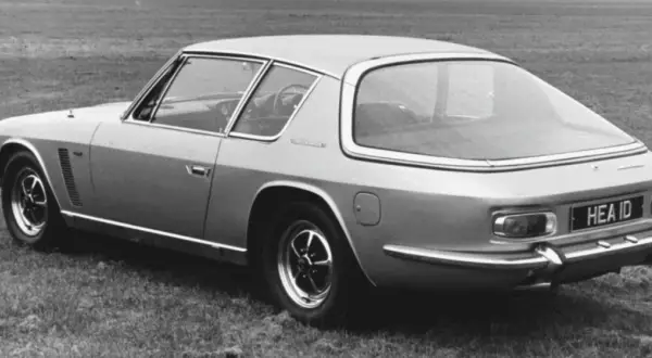 Ein Jensen Interceptor Auto steht auf einer Wiese. Das Heck des Wagens mit dem Kennzeichen "HEA ID" ist zu sehen.