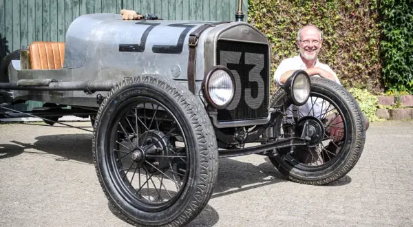 Ein Mann lächelt neben einem Oldtimer mit der Nummer 53. Wann ist ein Youngtimer steuerfrei?