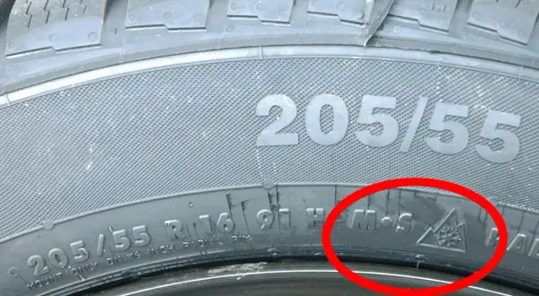 Nahaufnahme eines Reifens mit der Kennzeichnung 205/55 R16. Das M+S-Symbol und das Schneeflockensymbol im Dreieck bestätigen die Kennzeichnung Winterreifen.