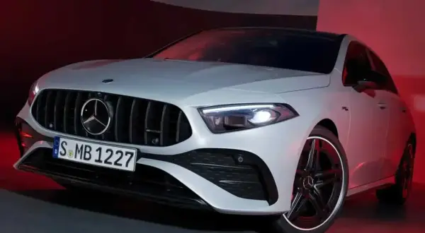 Sportlicher Mercedes A-Klasse mit markantem Kühlergrill und LED-Scheinwerfern, beleuchtet von rotem Licht.
