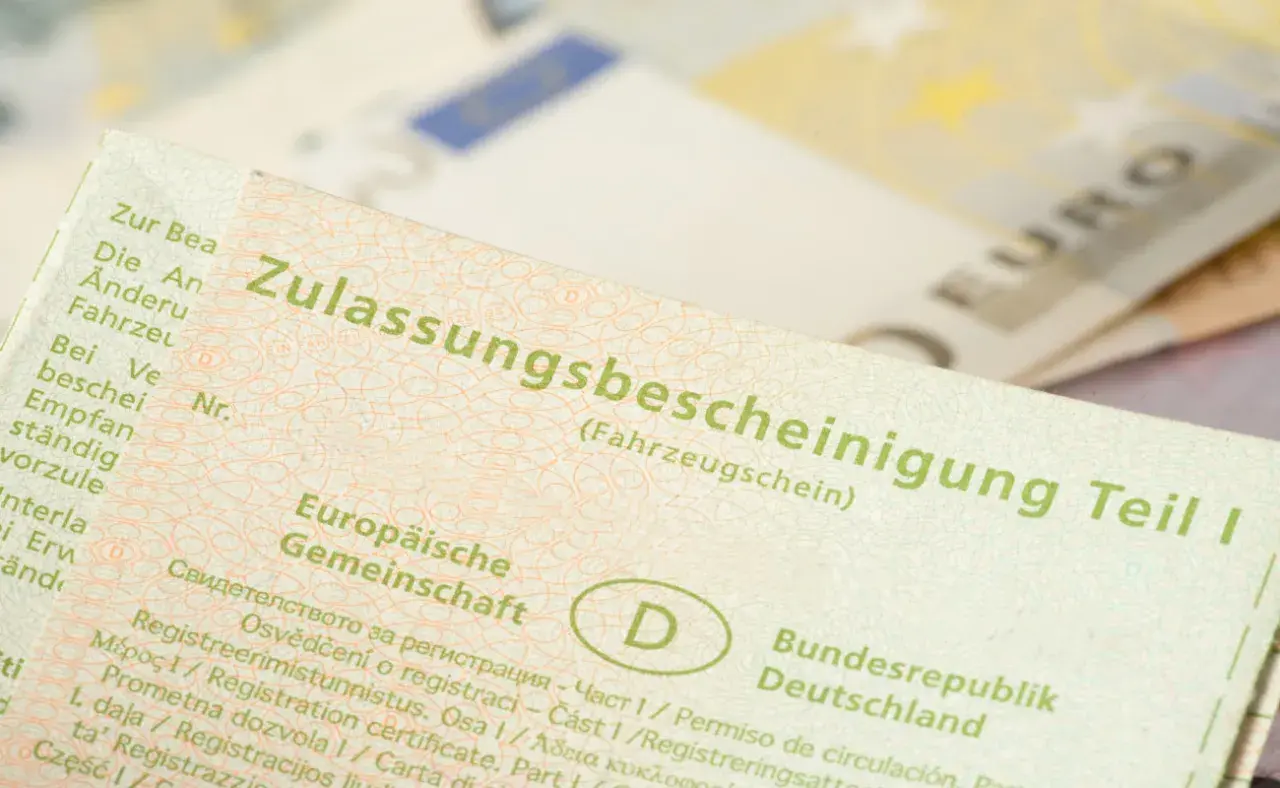 Zulassungsbescheinigung Teil I. Wichtig für auto abmelden nach verkauf ohne brief. Euroscheine im Hintergrund.