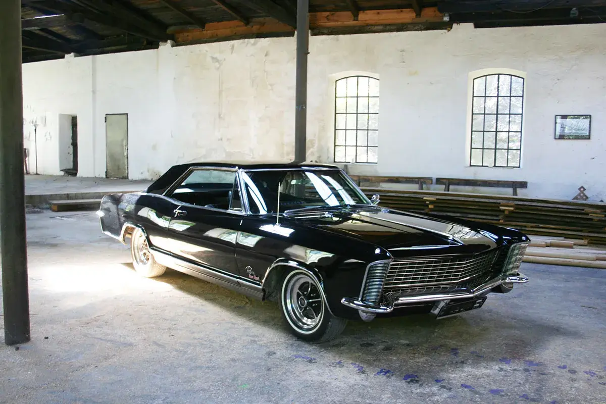 Glänzendes schwarzes Buick Auto steht in einer alten Halle.