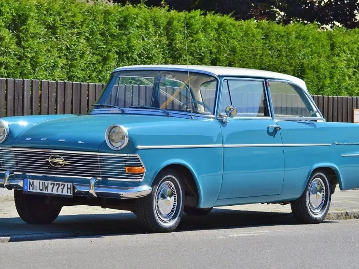 Blauer Oldtimer mit weißem Dach und dem Kennzeichen M UW 777 H. Ein Klassiker auf der Straße.