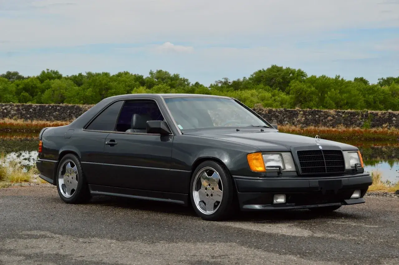 Dunkelgrauer Mercedes Hammer Coupe mit sportlichen Felgen steht am Wasser.