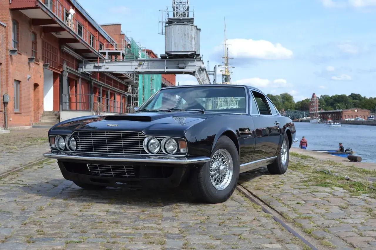 Schwarzer Aston Martin DBS, ein Klassiker unter den englischen automarken 1960, steht am Hafen.