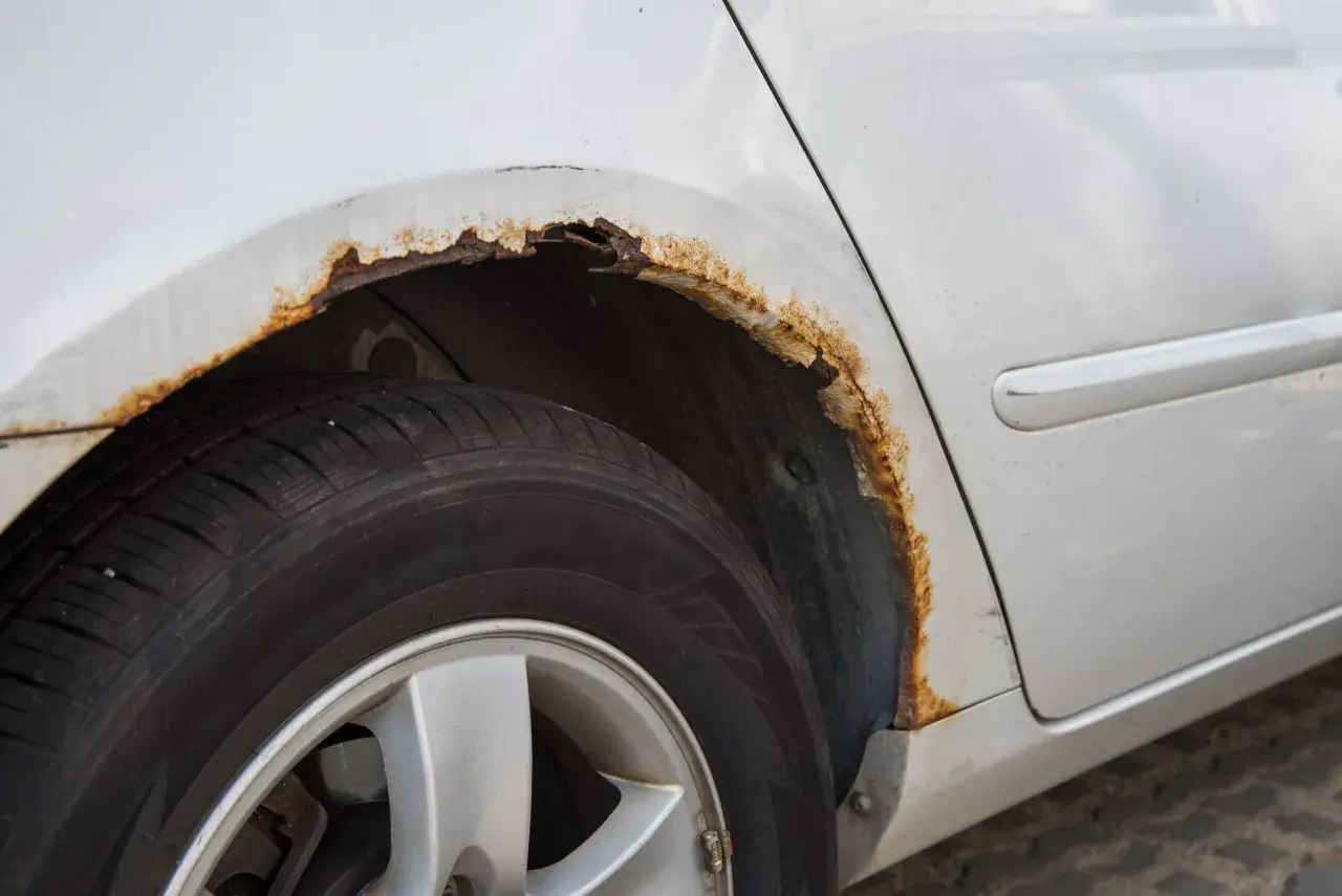 Rost am Auto: Ein Radkasten zeigt deutliche Spuren von Korrosion. Hier sieht man, wie entsteht rost am auto durch Feuchtigkeit und Salz.