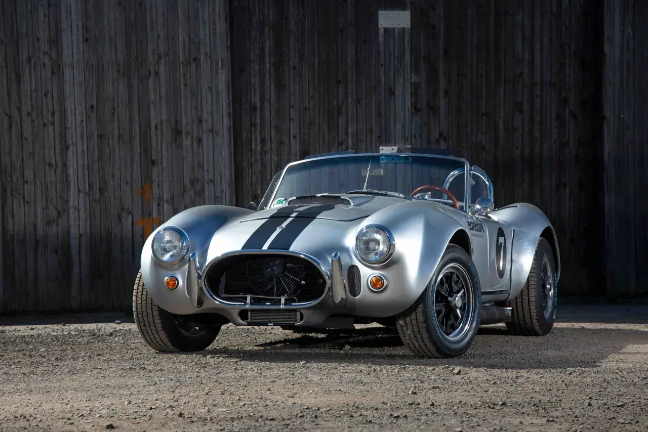 Silberner Cobra Shelby mit schwarzen Streifen, bereit für die Rennstrecke.