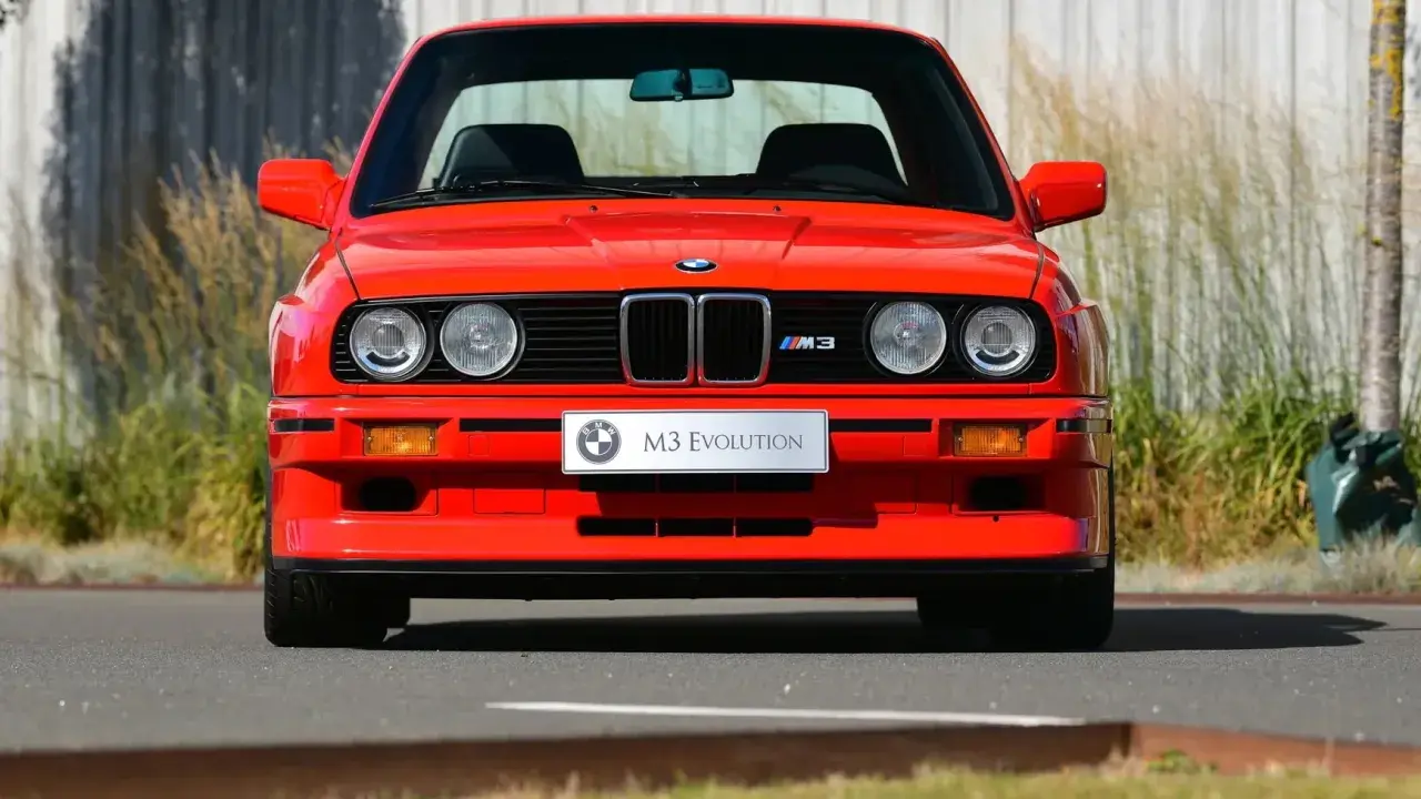 Roter BMW E30 M3 Evolution, ein Klassiker aus den 80ern, steht im Freien.