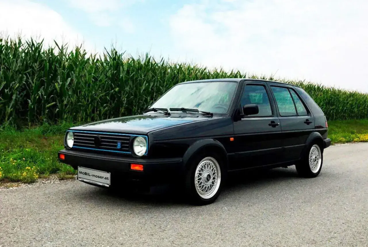 Schwarzer Golf 2 Limited mit blauen Akzenten steht am Feldrand.
