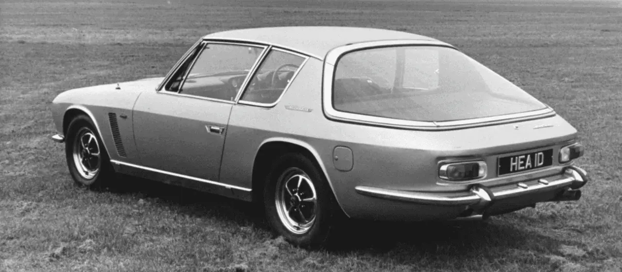 Ein Jensen Interceptor Auto steht auf einer Wiese. Das Heck des Wagens mit dem Kennzeichen "HEA ID" ist zu sehen.