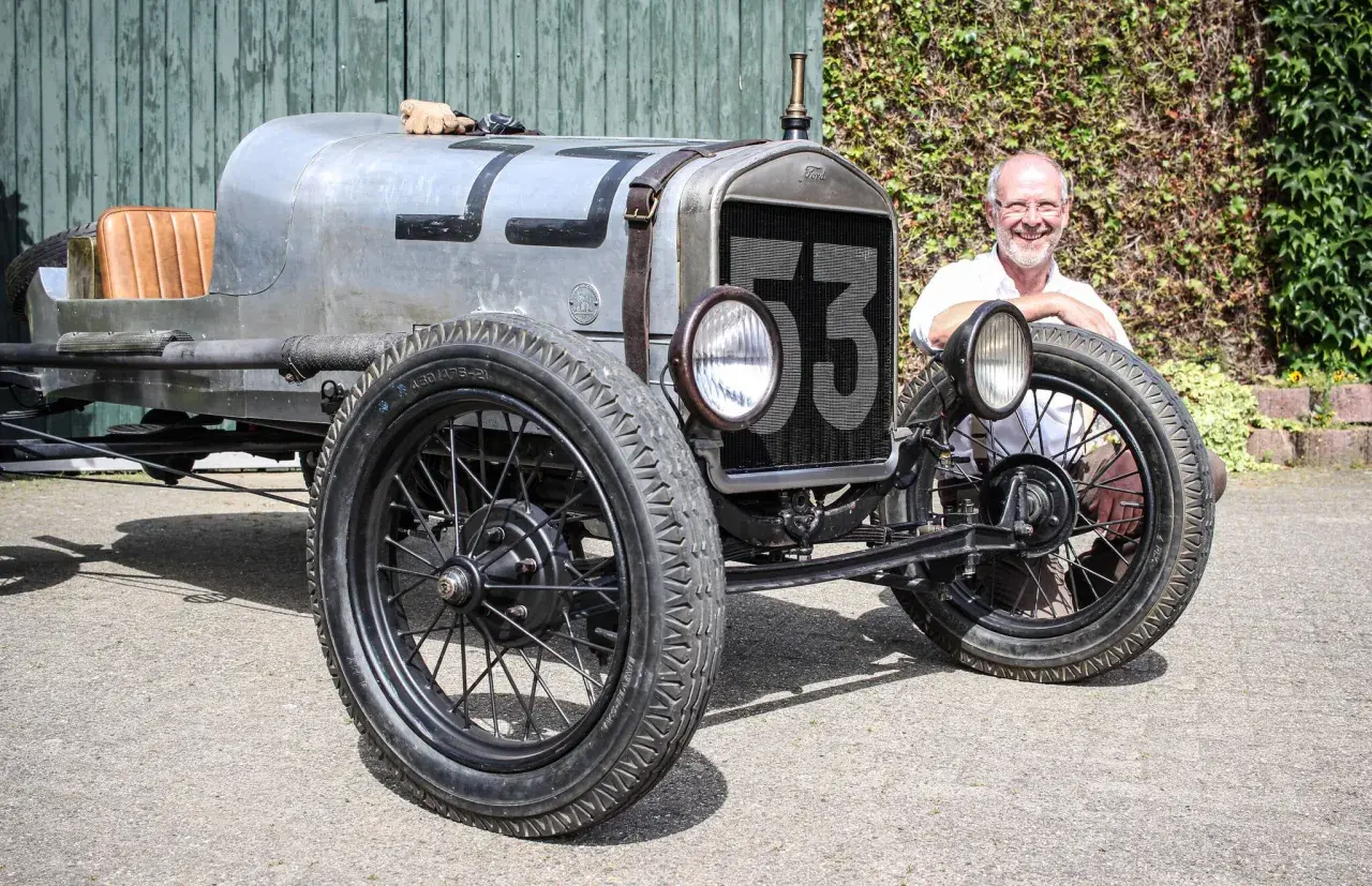Ein Mann lächelt neben einem Oldtimer mit der Nummer 53. Wann ist ein Youngtimer steuerfrei?