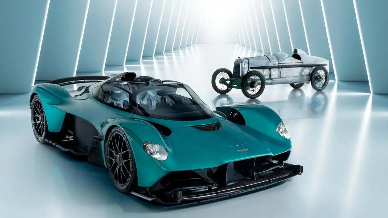 Ein moderner Aston Martin Valkyrie neben einem historischen Rennwagen.