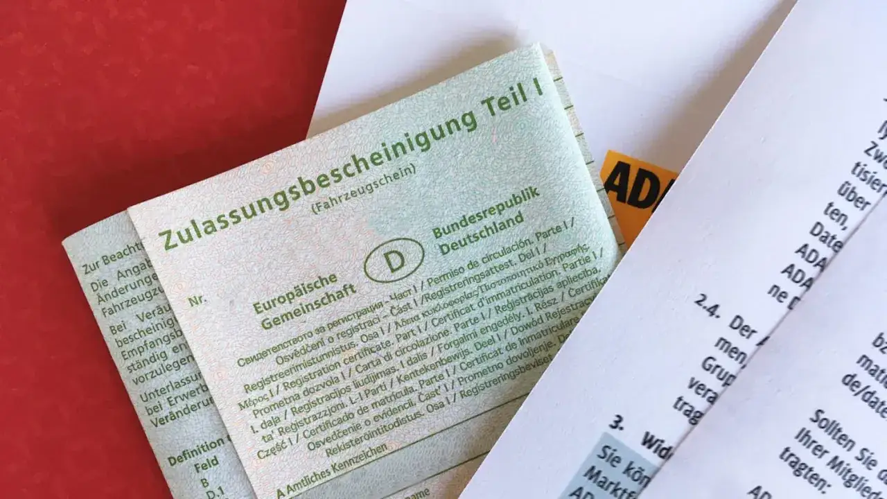Zulassungsbescheinigung Teil I (Fahrzeugschein) für das auto anmelden ohne zulassungsbescheinigung teil 1. ADA-Dokumente im Hintergrund.
