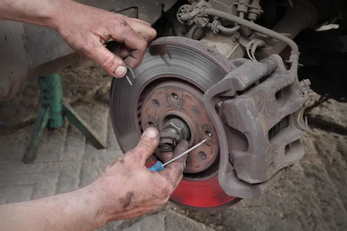Mechaniker wechselt Radlager. Die Kosten f&uuml;r den Radlagerwechsel sind oft &uuml;berschaubar, wenn man es selbst macht.
