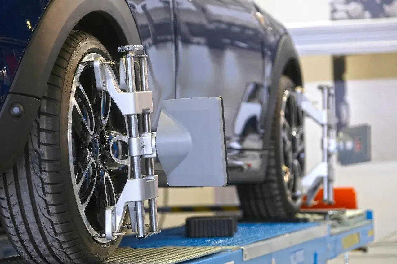 Messung der Achsgeometrie: So verstellt sich die Spur beim Auto. Pr&auml;zisionsmessger&auml;te an den R&auml;dern eines dunklen Autos.