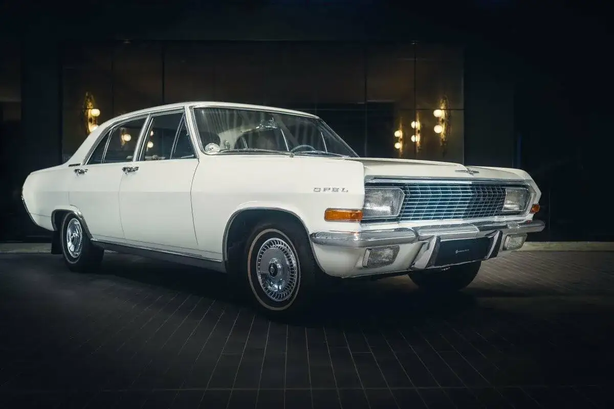 Wei&szlig;er Opel Admiral, ein Klassiker mit Chromdetails und elegantem Design, steht im Scheinwerferlicht.