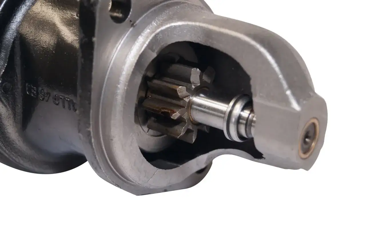 Detailaufnahme eines Anlassers mit freiliegendem Ritzel. Dieses Bauteil ist entscheidend, um zu verstehen, was ein Anlasser ist: Er startet den Motor.